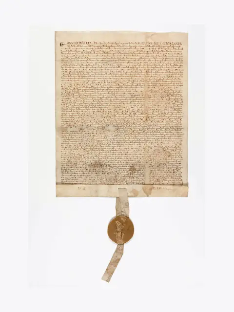 2 1st An ancient document with handwritten Latin text, featuring a wax seal attached by a ribbon at the bottom.